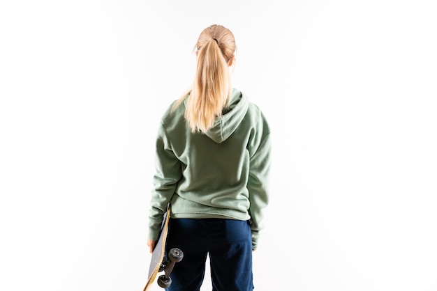 Blonde teenager skater girl over isolated white background