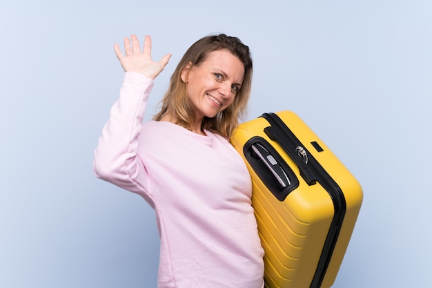 Blonde traveler woman over isolated wall