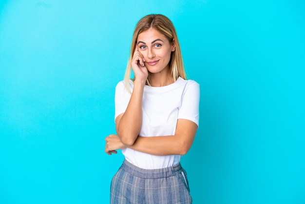 Blonde Uruguayan girl isolated on blue background thinking an idea