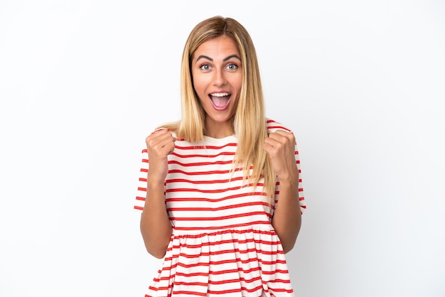 Blonde Uruguayan girl isolated on white background celebrating a victory in winner position