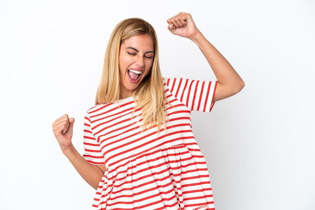 Blonde Uruguayan girl isolated on white background celebrating a victory