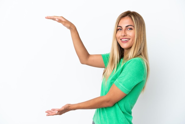 Blonde Uruguayan girl isolated on white background holding copyspace to insert an ad