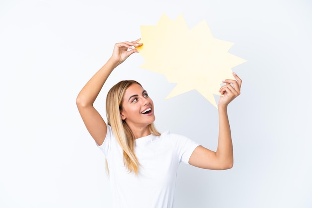 Blonde Uruguayan girl isolated on white background holding an empty speech bubble and having doubts