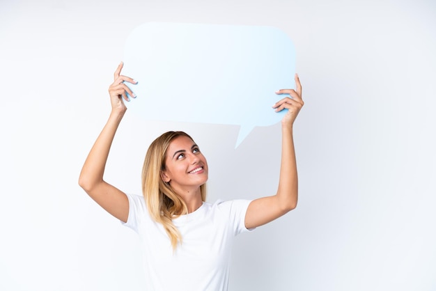 Blonde Uruguayan girl isolated on white background holding an empty speech bubble