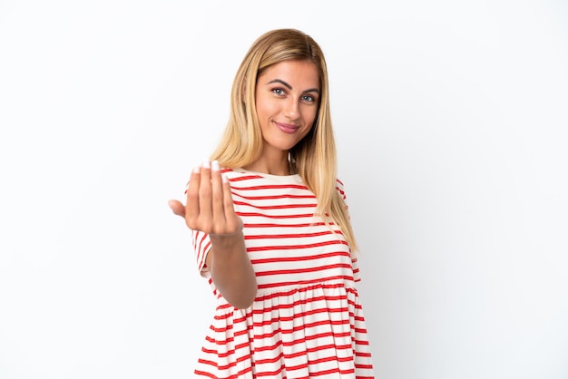 Blonde Uruguayan girl isolated on white background inviting to come with hand Happy that you came