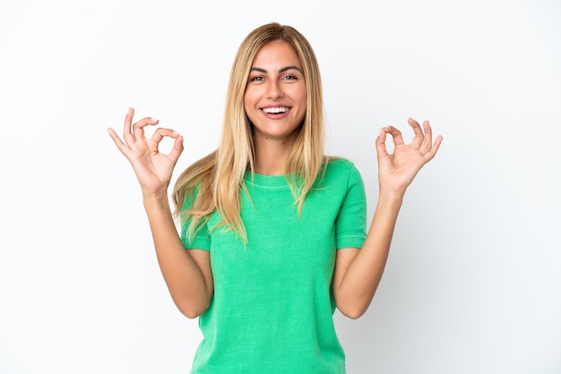 Blonde Uruguayan girl isolated on white background in zen pose