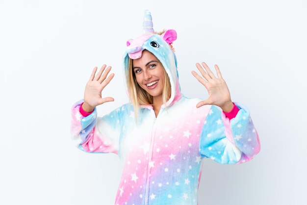 Blonde Uruguayan girl wearing a unicorn pajama isolated on white background counting ten with fingers