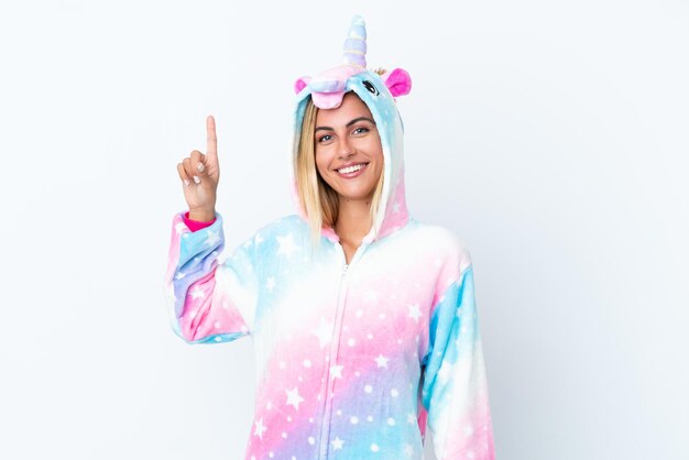 Blonde Uruguayan girl wearing a unicorn pajama isolated on white background showing and lifting a finger in sign of the best