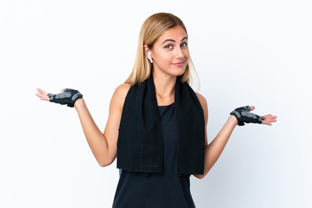 Blonde Uruguayan sport girl isolated on white background having doubts while raising hands