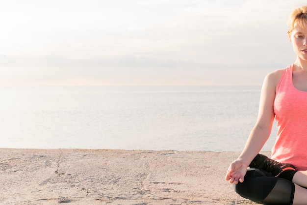 Blonde vrouw beoefenen van yoga in de lotuspositie