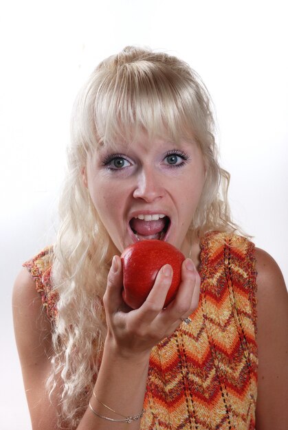 Blonde vrouw die een appel eet