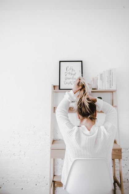 Blonde vrouw die haar haar bindt, minimale levensstijlfoto