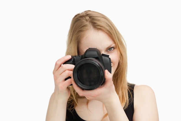 Blonde vrouw die met een camera streeft