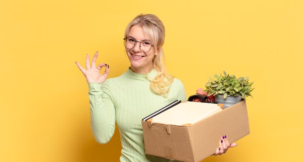 blonde vrouw die zich gelukkig, ontspannen en tevreden voelt, goedkeuring toont met een goed gebaar, glimlachend