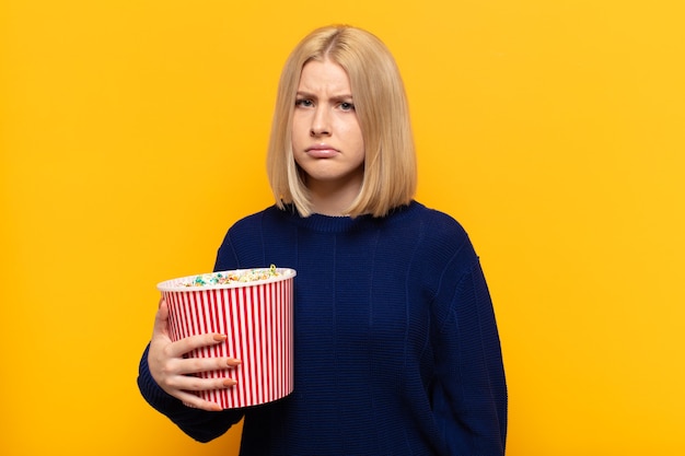 Blonde vrouw die zich verdrietig en zeurderig voelt met een ongelukkige blik, huilt met een negatieve en gefrustreerde houding