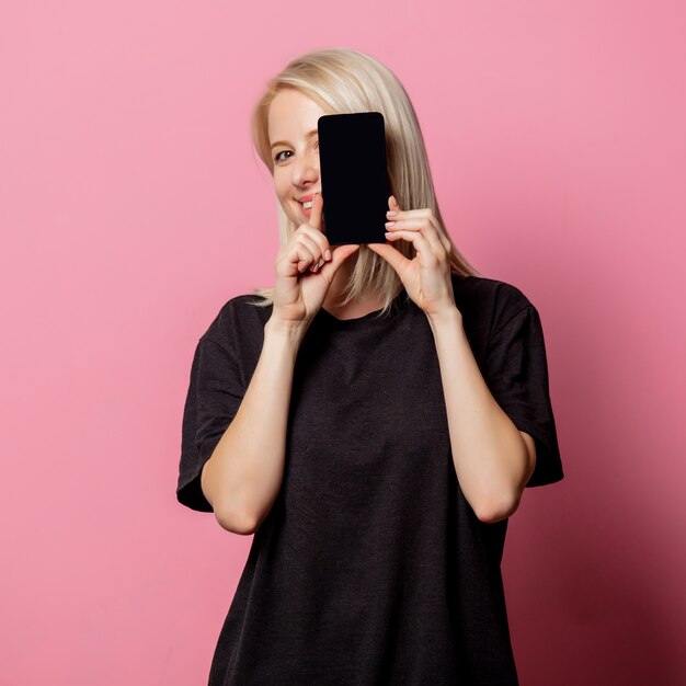 Blonde vrouw in zwarte t-shirt en mobiele telefoon