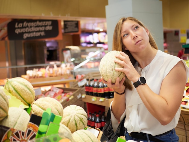 Blonde vrouw koopt fruit bij supermarkt