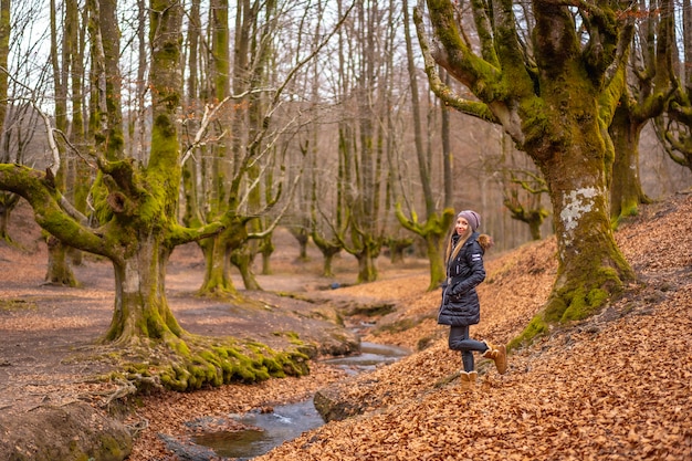 blonde vrouw met een lange jas in een bos