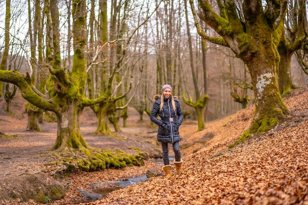 blonde vrouw met een lange jas in een bos