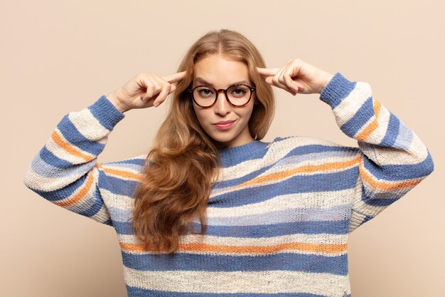 blonde vrouw met een serieuze en geconcentreerde blik, die brainstormt en nadenkt over een uitdagend probleem