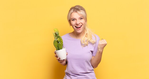 Blonde vrouw met gebalde vuisten vieren succes