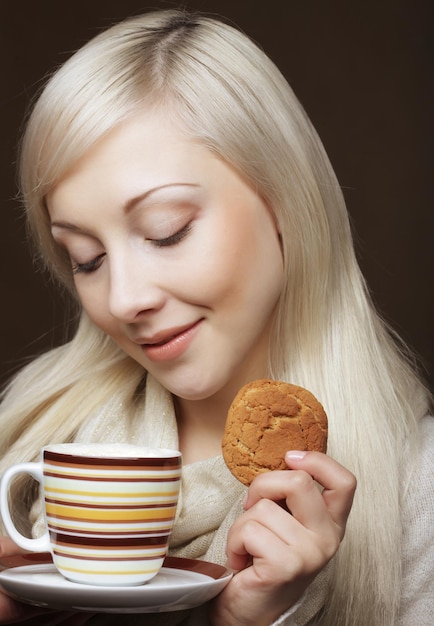 Blonde vrouw met koffie en koekjes