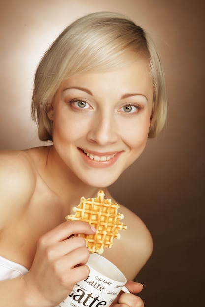 Blonde vrouw met koffie en koekjes