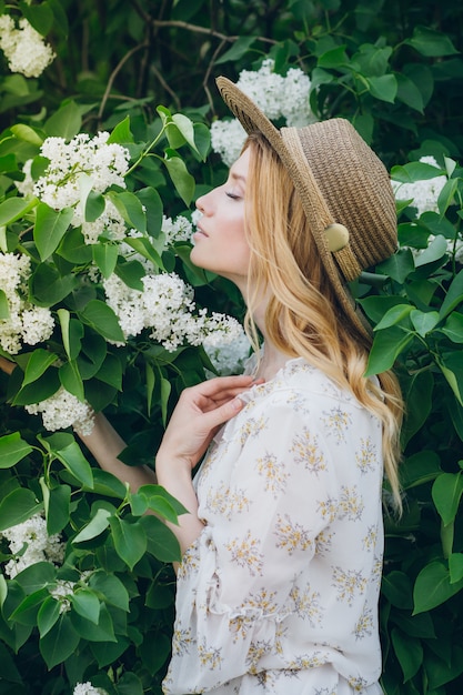 Blonde vrouw met lila bloemen in de lente