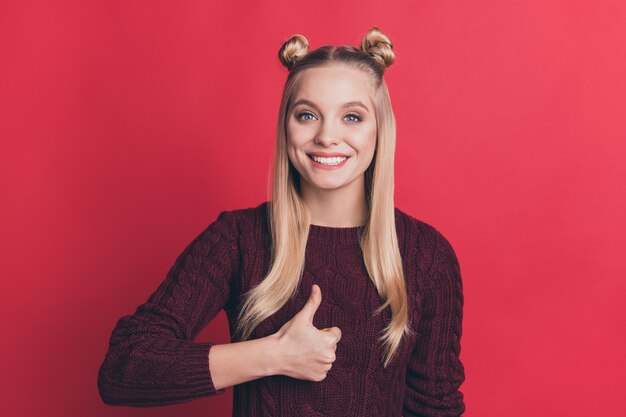 blonde vrouw met top-knopen poseren tegen de rode muur