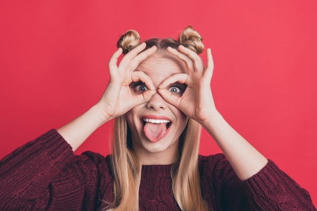 blonde vrouw met top-knopen poseren tegen de rode muur