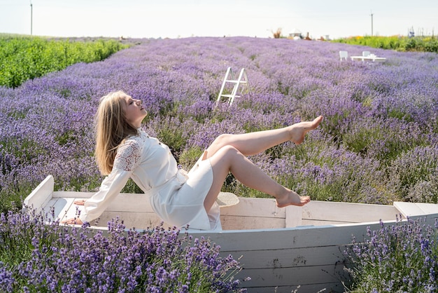 Blonde vrouw poseren met versieringen gelegen aan lavendelveld