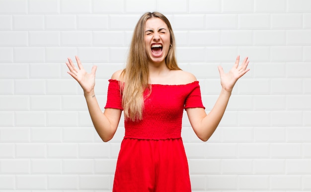 Blonde vrouw schreeuwde woedend, voelde zich gestrest en geïrriteerd met de handen in de lucht en zei waarom ik