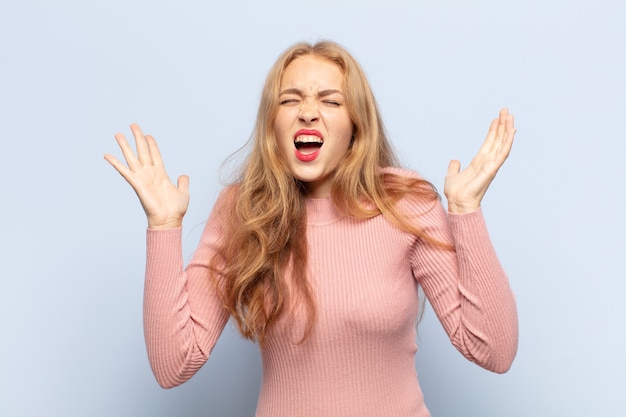 blonde vrouw schreeuwde woedend, voelde zich gestrest en geïrriteerd met de handen in de lucht en zei waarom ik