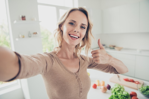 Blonde vrouw thuis in de keuken met groenten