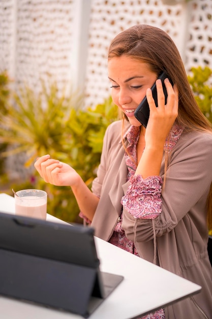 Blonde vrouw uitvoerende zakenvrouw of financier met een koffie cafeïnevrij ontbijt praten aan de telefoon