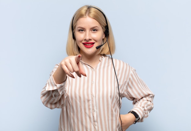 Blonde vrouw wijzend op camera met een tevreden, zelfverzekerde, vriendelijke glimlach, die jou kiest