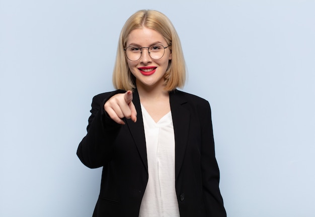 Blonde vrouw wijzend op camera met een tevreden, zelfverzekerde, vriendelijke glimlach, die jou kiest