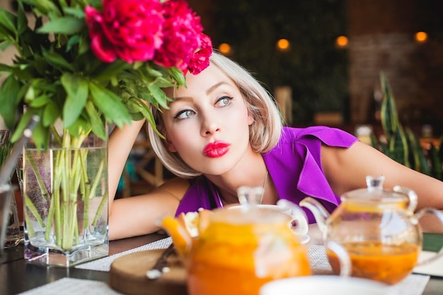 Blonde vrouw zit in restaurant