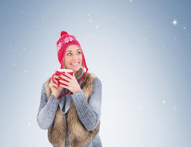 Blonde in winter clothes holding a mug