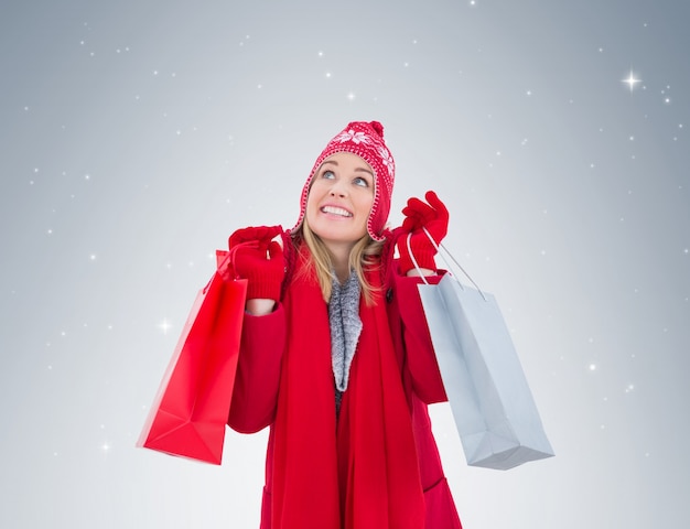 Foto bionda in abiti invernali in possesso di borse per la spesa
