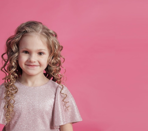 Blonde with curly hair close-up on pink background