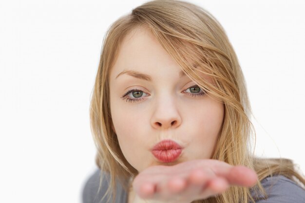 Blonde woman blowing on her palm