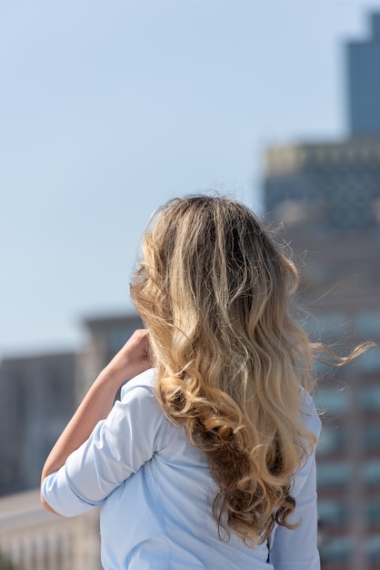 Blonde woman in blue shirt posing