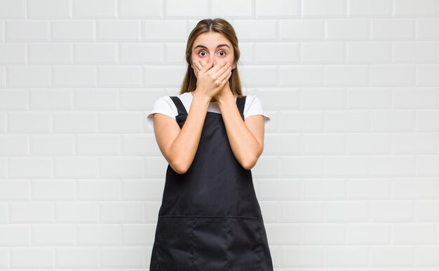 Blonde woman covering mouth with hands