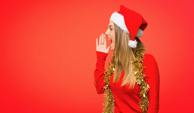 Blonde woman dressed up for christmas holidays shouting to the lateral