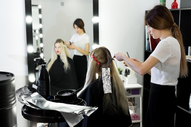 blonde woman dying her hair at the beauty salon
