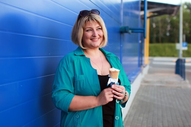 La donna bionda mangia il gelato all'aperto