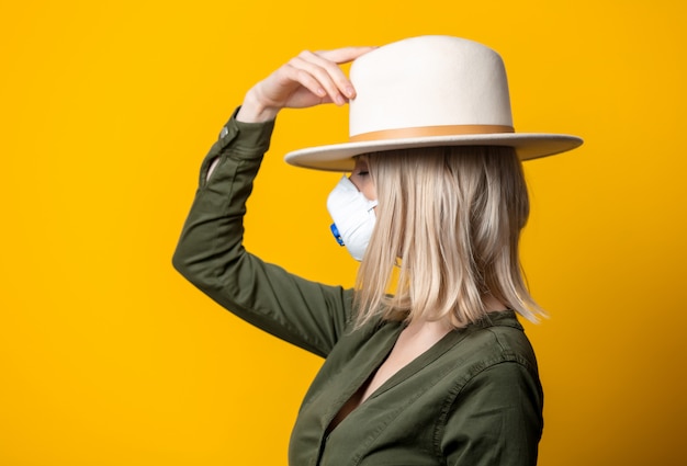 Photo blonde woman in face mask, hat and green shirt