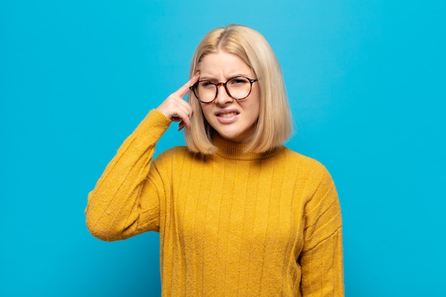 Blonde woman feeling confused and puzzled, showing you are insane, crazy or out of your mind