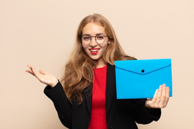 Blonde woman feeling happy, surprised and cheerful, smiling with positive attitude, realizing a solution or idea